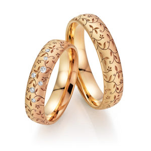 Goldene Eheringe mit Blumenmuster