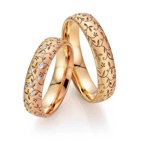 Goldene Eheringe mit Blumenmuster