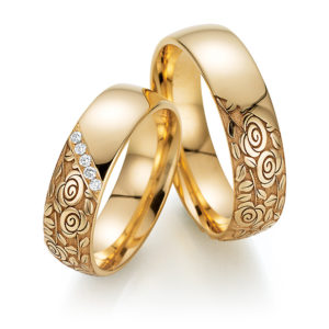 Goldene Eheringe mit Rosenmuster
