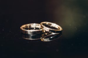 Two gold rings with gemstone and engraving on a black background