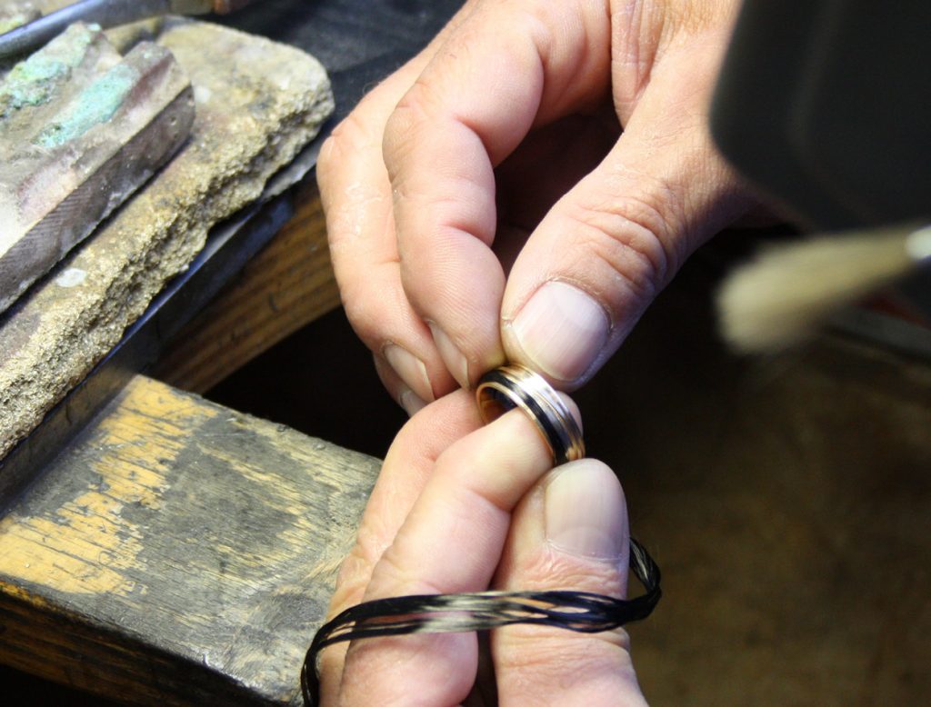 Goldsmith makes wedding rings from white gold and gray gold