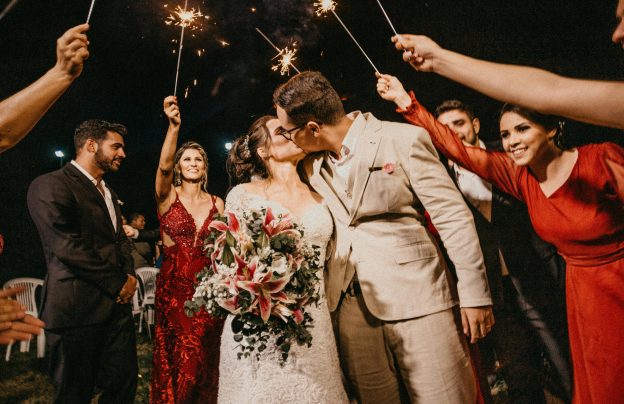 Emotionaler Hochzeitsmoment nach der Ringübergabe: Brautpaar küsst sich mit Wunderkerzen