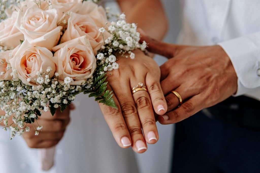 Braut und Bräutigam zeigen ihre Eheringe nach der Hochzeit“