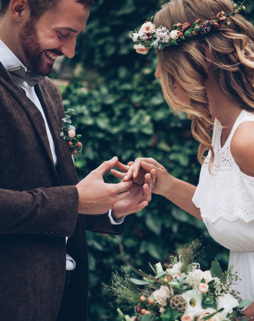 Brautpaar tauscht Ringe, symbolisiert Hochzeit und Liebe.