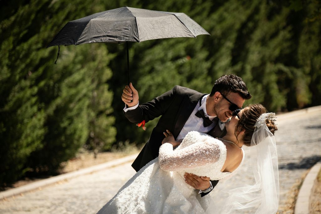 Paar unter Regenschirm mit Bäumen im Hintergrund