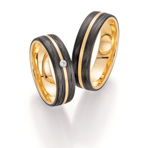 Wedding rings made of yellow gold and black carbon with fine diamond setting, made in Germany