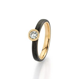 Yellow gold wedding ring with black carbon surface ring and oval brilliant-cut diamond, made in Germany