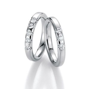 Three white gold diamond eternity rings with diamond settings on the sides, made in Germany