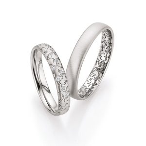 White gold wedding rings with filigree floral pattern and small diamonds